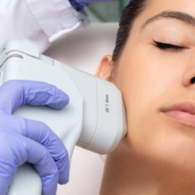 A woman getting her face cleaned by an esthetician.