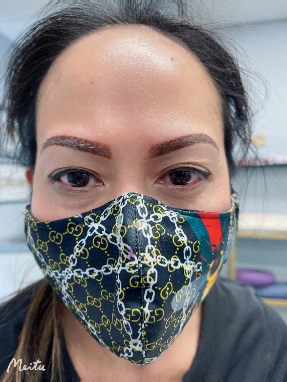 A woman wearing a face mask with chains on it.