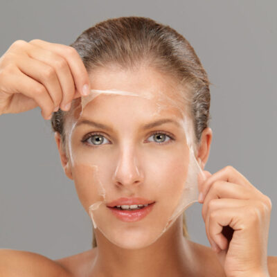 A woman is holding up a plastic bag over her face.