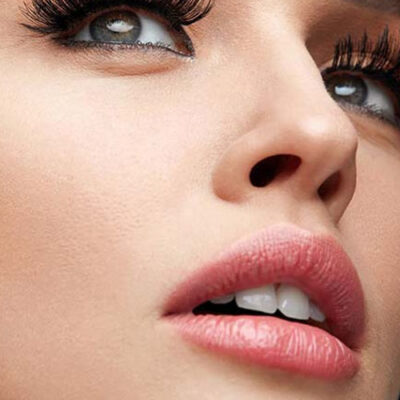 A close up of a woman 's face with long lashes.