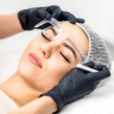 A woman getting her eyebrows threaded at the salon